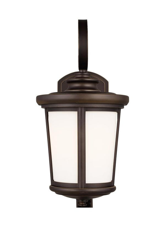 Generation Lighting Eddington modern 1-light outdoor exterior medium wall lantern sconce in antique bronze finish with cased opal etched glass panel 8619301-71